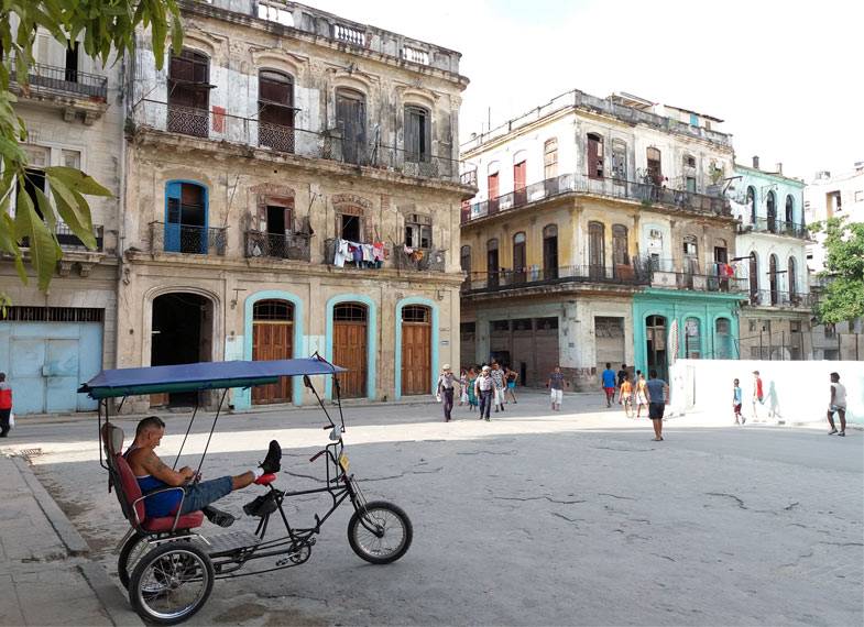 A bicycle taxi driver rests while waiting for a customer in Old Havana, Cuba A bicycle taxi driver rests while waiting for a customer in Old Havana, Cuba