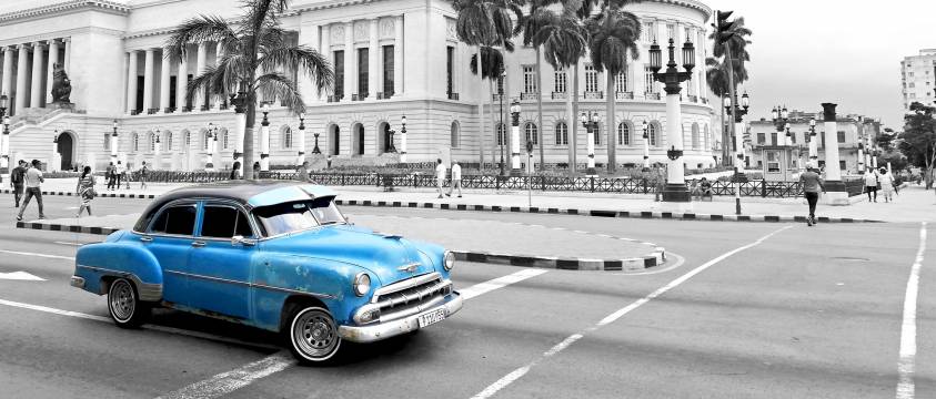 A blue 1950's Chevrolet in front of the Capitol building in Havana, Cuba