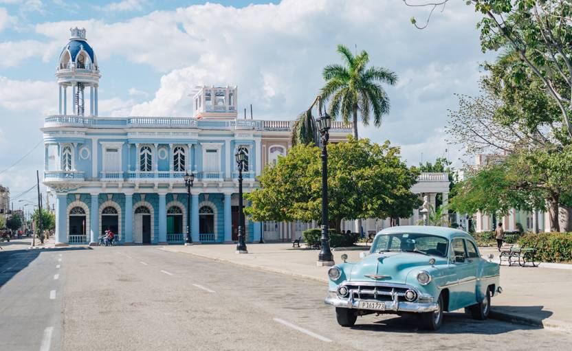 Cienfuegos has a very pleasant and picturesque main square A blue classic car parked next to the Parque Jose Marti in Cienfuegos, Cuba