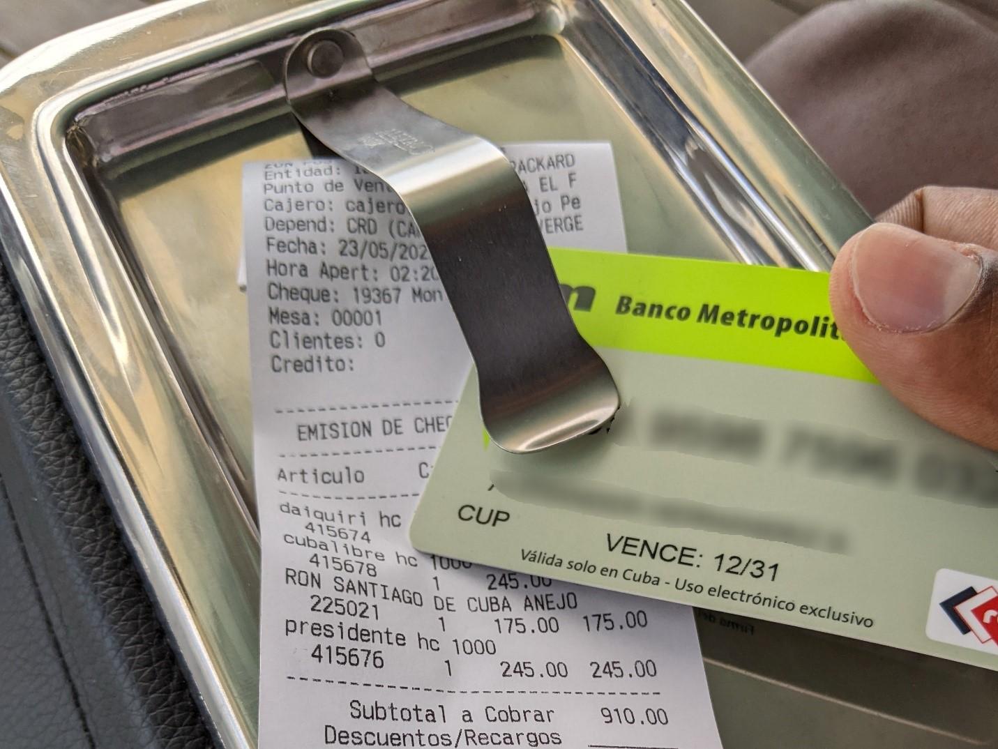 A debit card on top of a bill from a restaurant