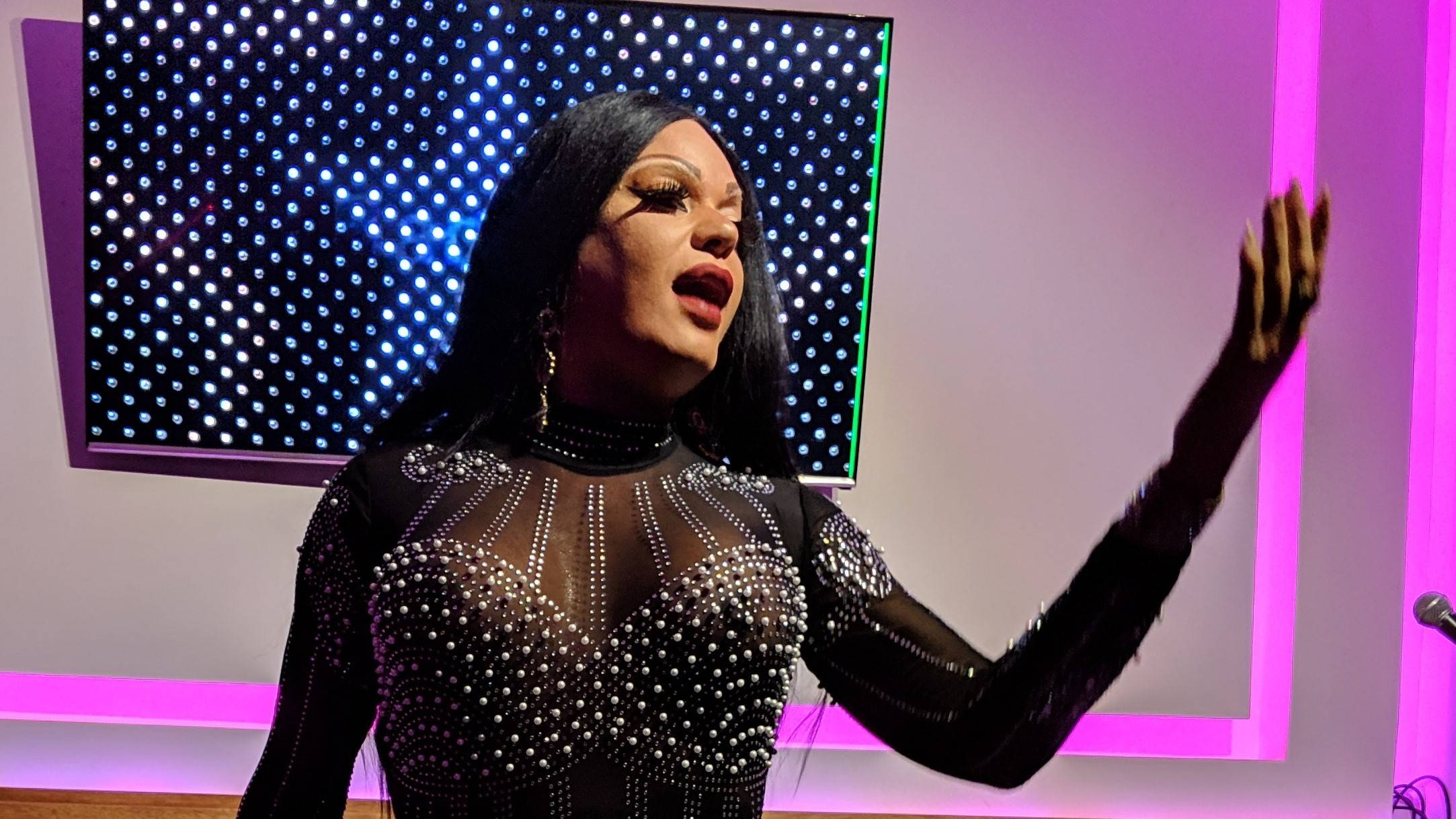 A drag performer sings A drag performer sings