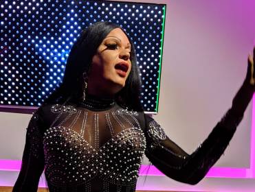 A drag performer sings