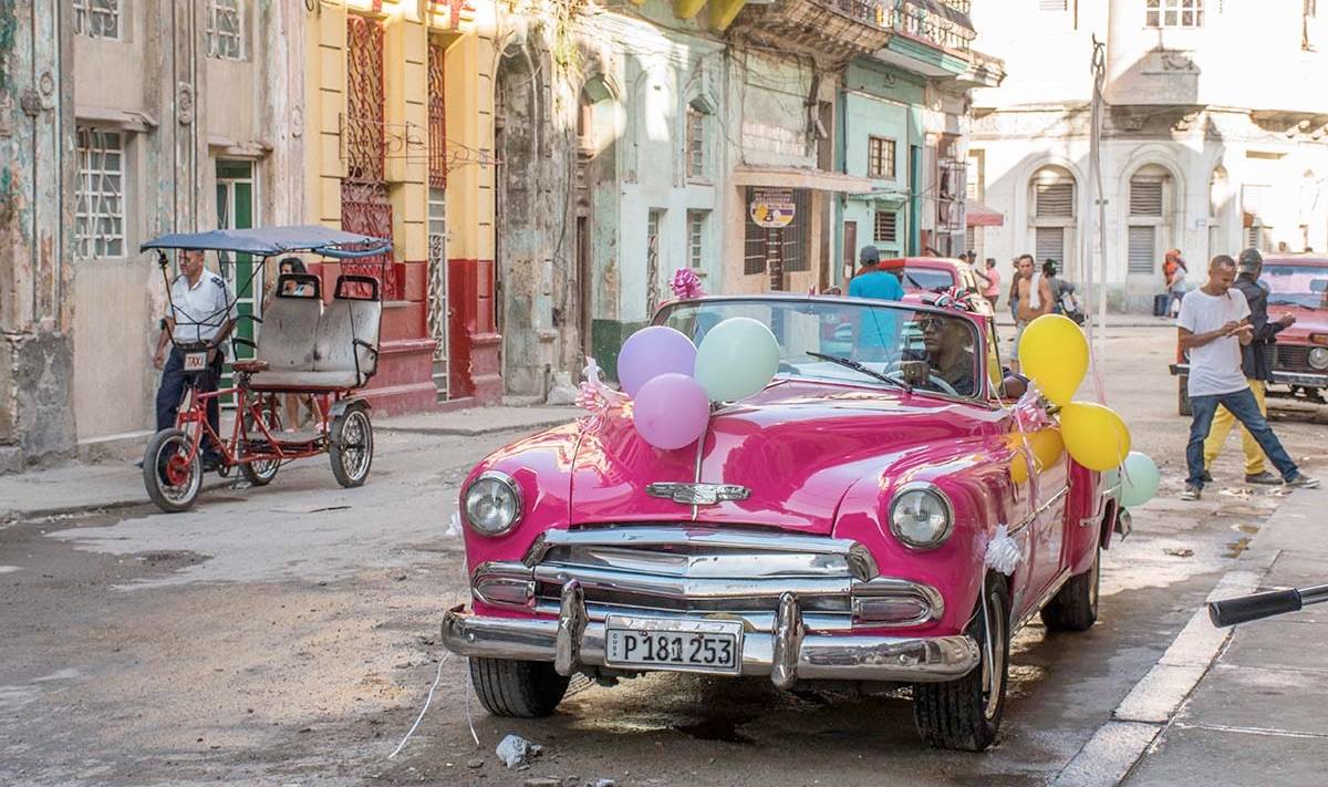 A pink American classic car with balloons in Havana A pink American classic car with balloons in Havana