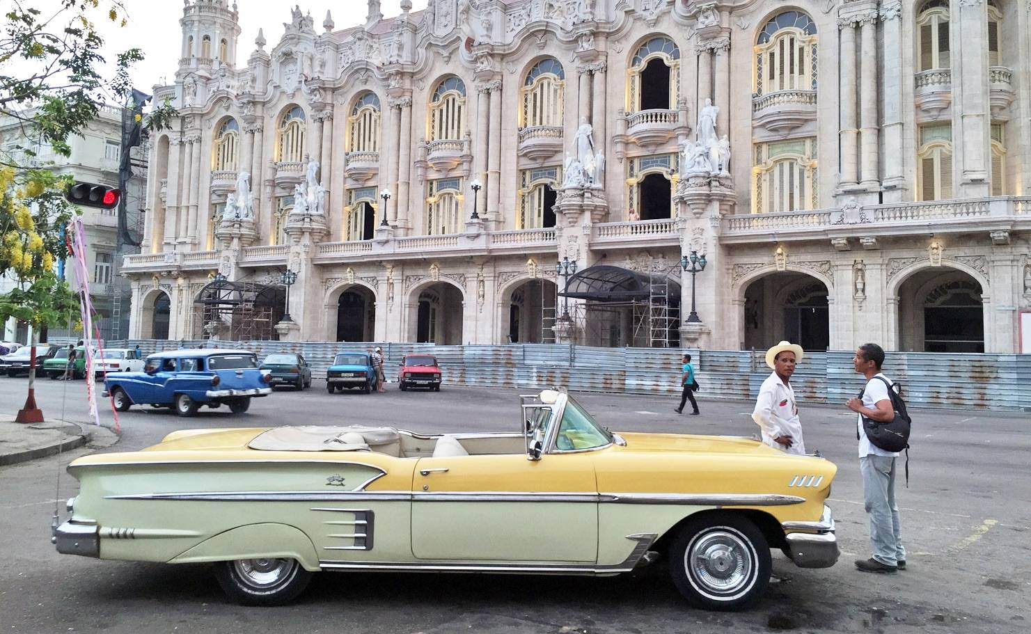A yellow classic American 50’s car in front of the Alicia Alonzo theatre in Havana A yellow classic American 50’s car in front of the Alicia Alonzo theatre in Havana