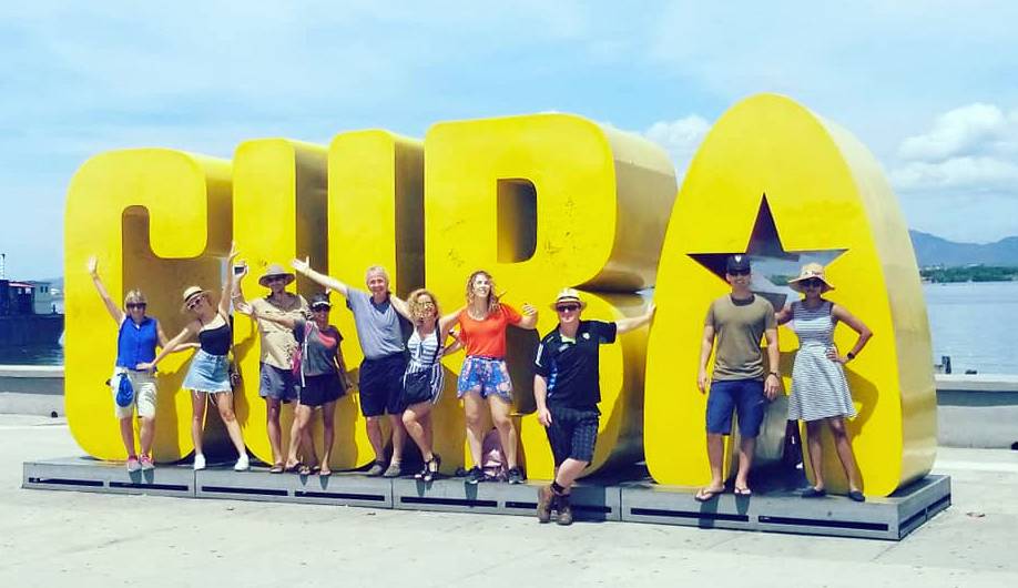 A Cuban Adventures tour group poses with the Cuba sign in Santiago de Cuba