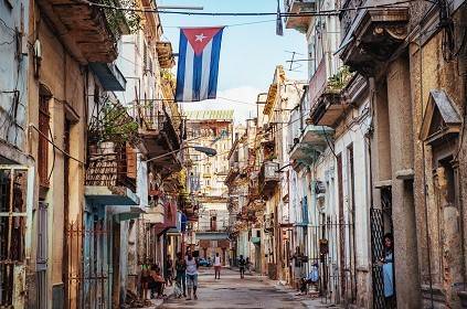 Cuba’s story is one of rebellion and perseverance Cuban flag over a narrow street in Old Havana