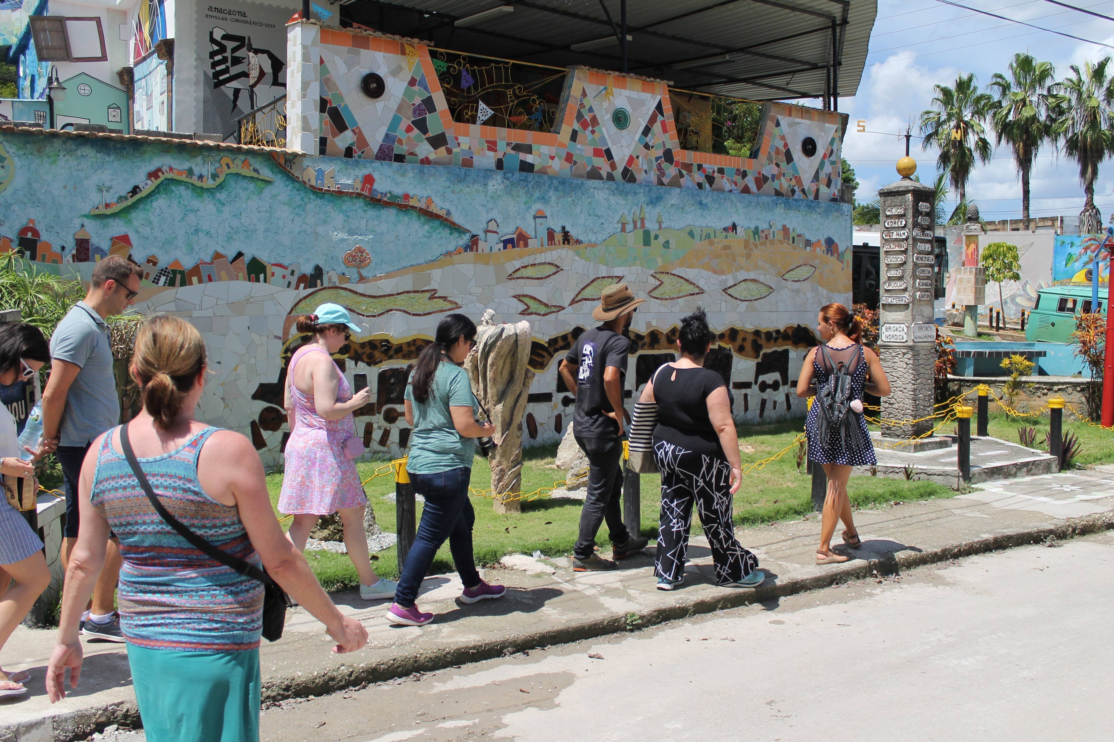 Cuban Adventures tour leader walking with group by a wall mural Cuban Adventures tour leader walking with group by a wall mural