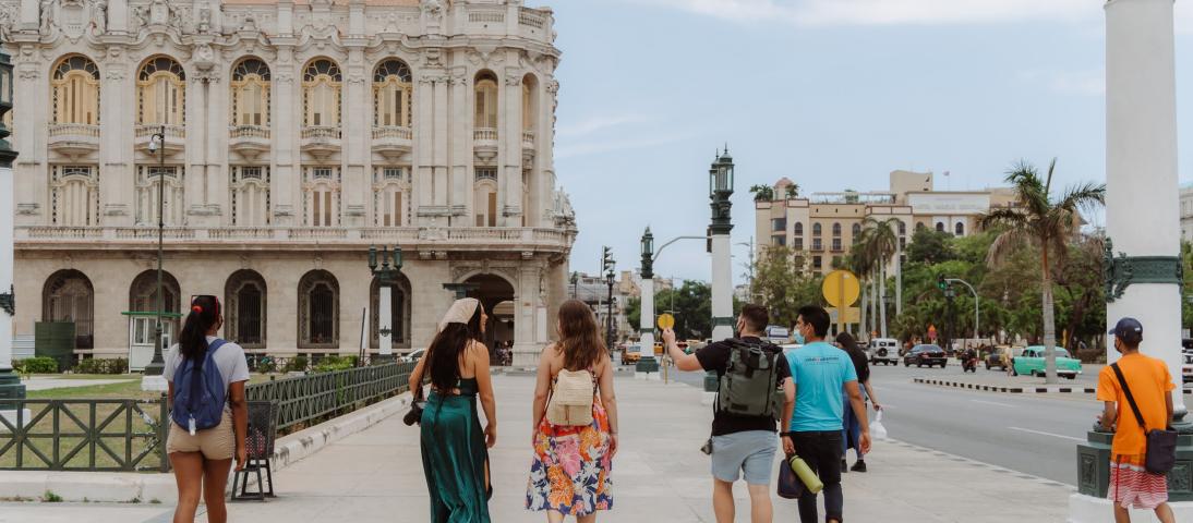 Distance shot of the back of a Cuban Adventures guide leading a group of tourists in Old Havana.