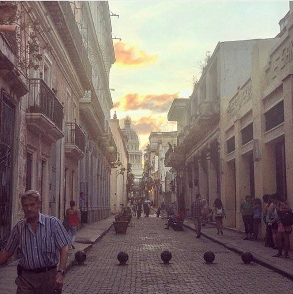 Exploring Old Havana on foot is a must narrow cobblestoned street with the domed capitol building looming in the background