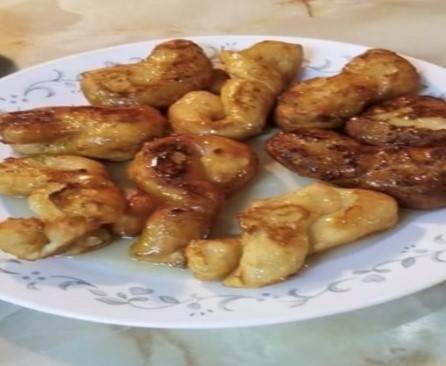 Golden fried buƱuelos on a white plate with floral decorated rim golden fried buƱuelos on a white plate with floral decorated rim