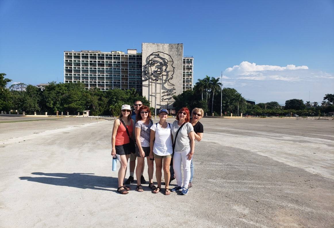 If you don't have your Che photo, have you really been to Havana? a group poses for a photo in front of a building decorated with a metal sculpture of Che Guevara