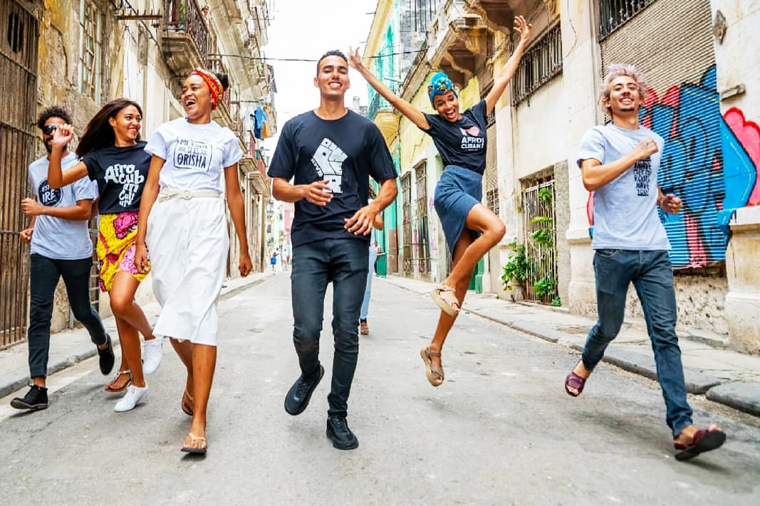 Photo Credit: Beyond Roots A cheerful group of hip 20-somethings walk down the street wearing designer Afro-Cuban themed t-shirts