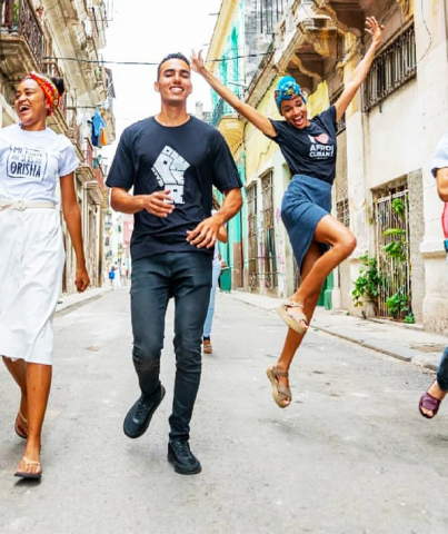 A cheerful group of hip 20-somethings walk down the street wearing designer Afro-Cuban themed t-shirts
