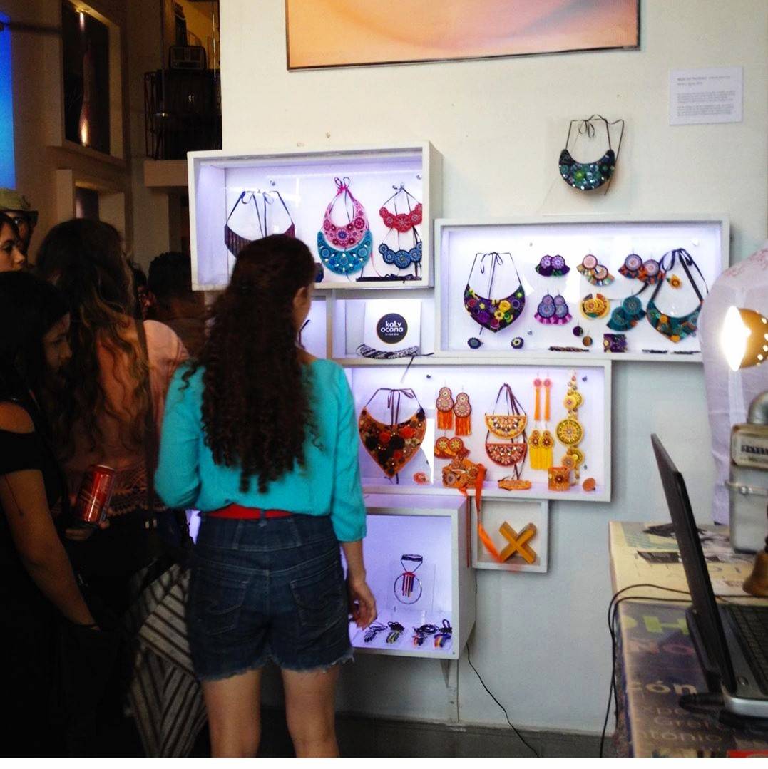 Photo Credit: Katy Ocaña two women browse a wall display of vibrantly colored statement jewelry