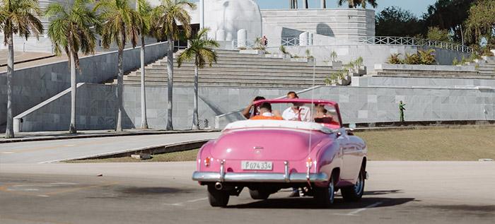 Pink car passing by Plaza de la Revolucion