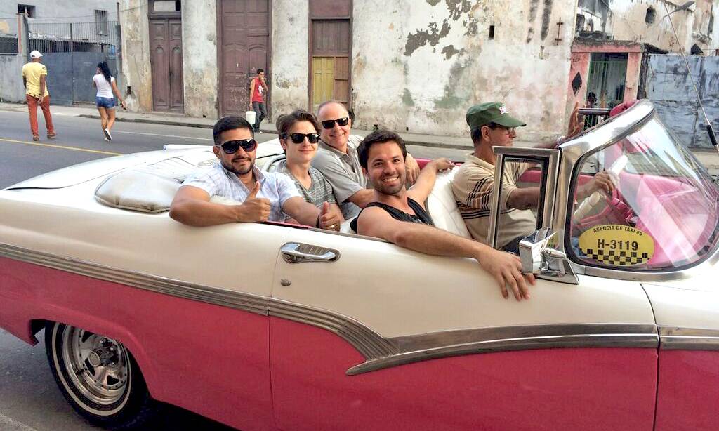 Some travellers taking a tour of Havana in a convertible classic American car in Havana