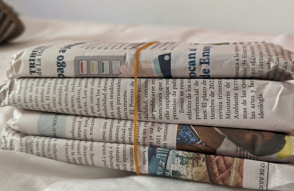 four thick stacks of money wrapped in newspaper