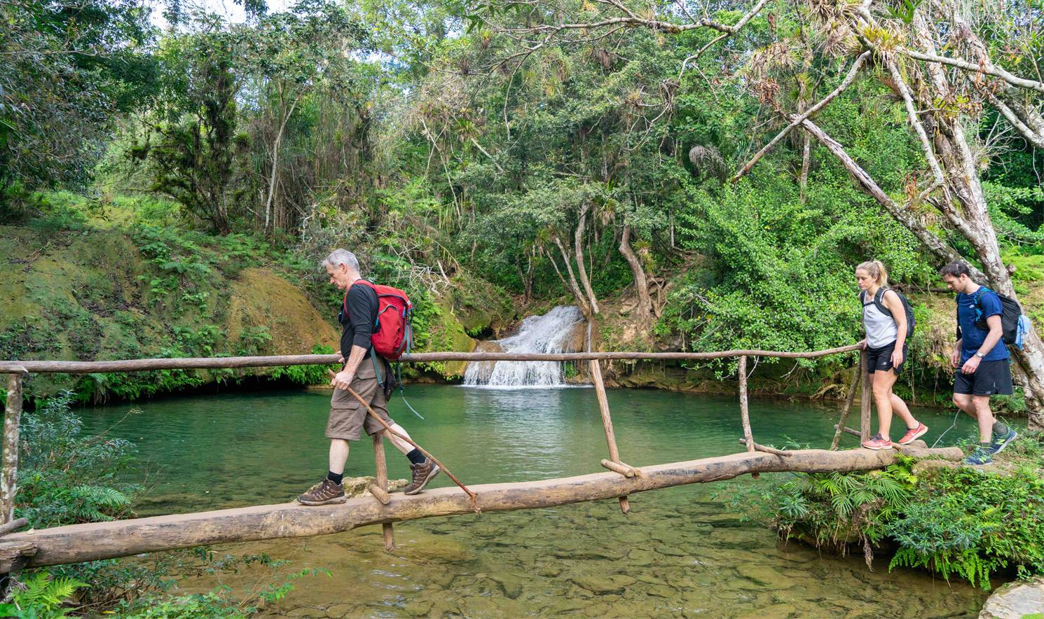 Trekking past a waterfall on the way to Rocio waterfall in Parque Guanayara, Topes de Collantes, Cuba Trekking past a waterfall on the way to Rocio waterfall in Parque Guanayara, Topes de Collantes, Cuba