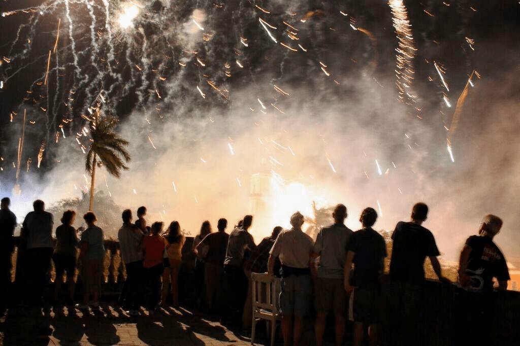 Visitors to the Remedios festival watch the fireworks display from a rooftop. Visitors to the Remedios festival watch the fireworks display from a rooftop.